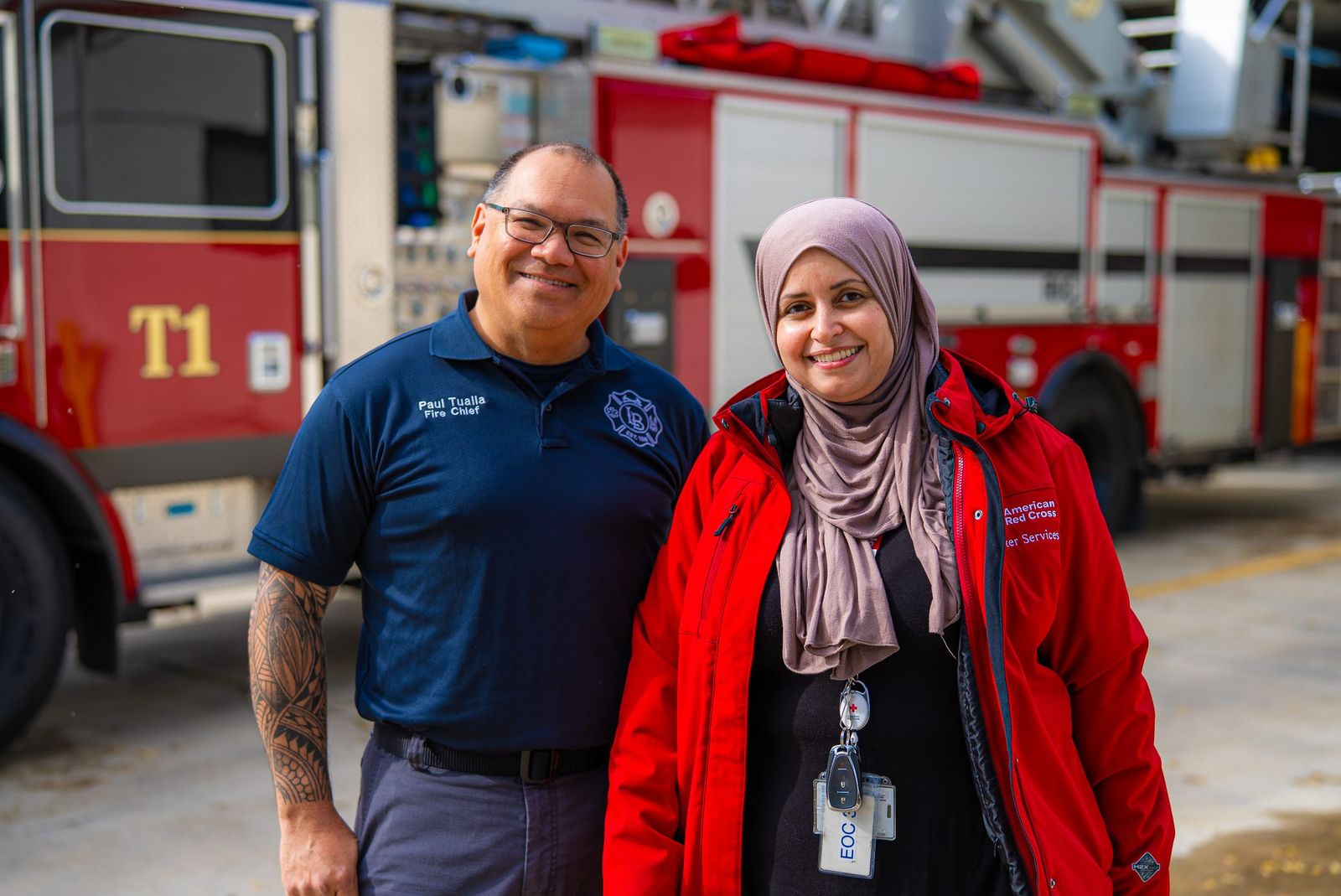 A Los Banos fire chief and an American Red Cross volunteer in front of a fire engine during a Sound the Alarm event