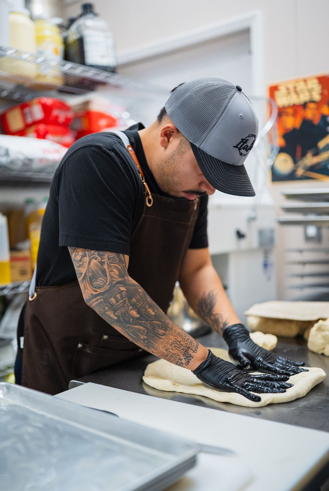 A cook in a cap stretching dough
