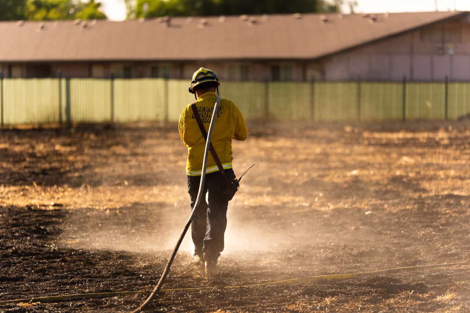 Hose line through backlit dust — Los Banos Fire Department