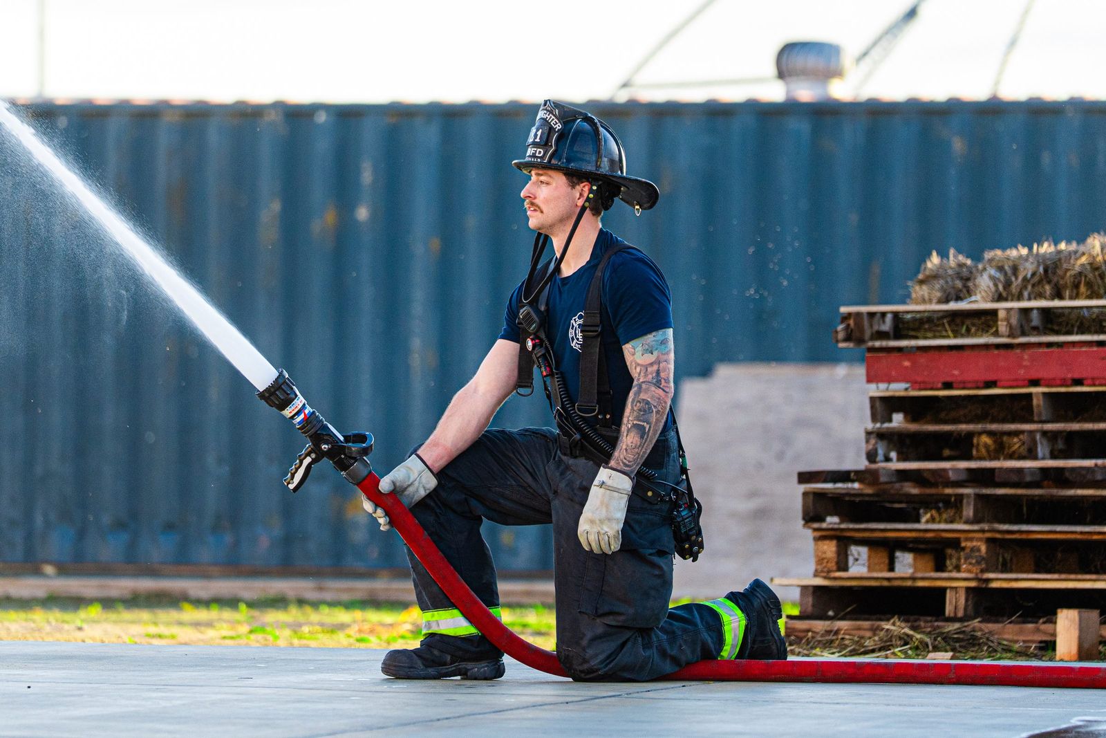 Kneeling with the hose — Los Banos Fire Department