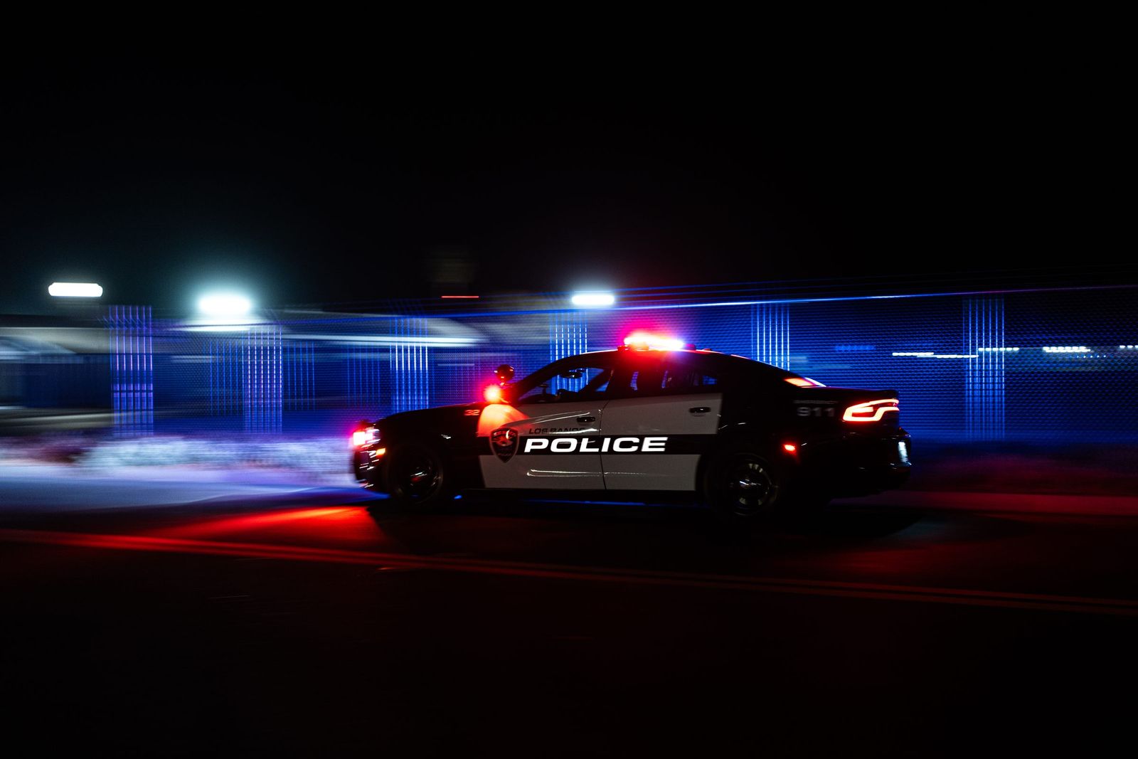 Patrol car in motion at night — Los Banos Police Department