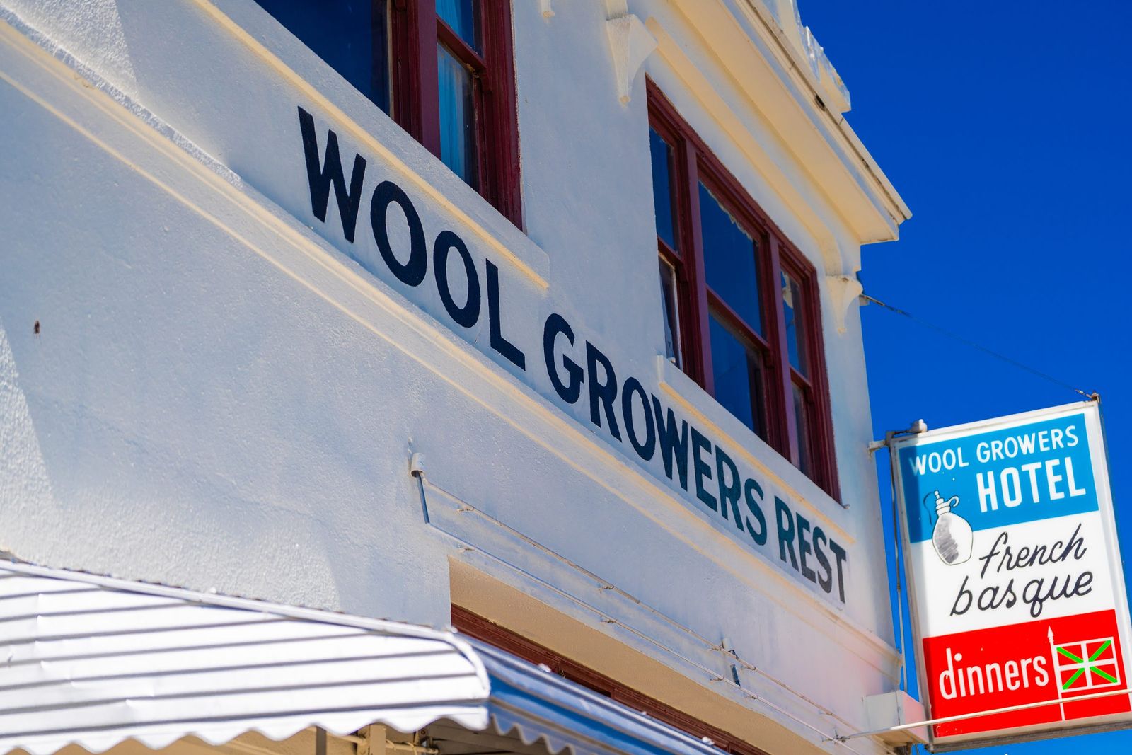 Painted sign against blue sky — Wool Growers Restaurant